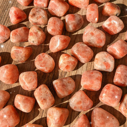 Macro view of sunstone tumbled stones showing polished surfaces, colour variation and natural markings