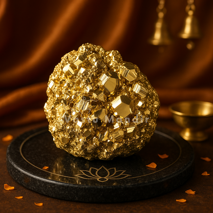 Golden pyrite cluster displayed on a black pedestal against a warm dark background