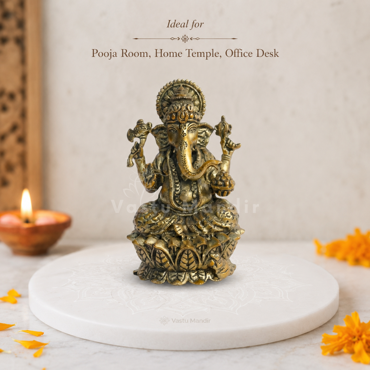 Brass Ganesha idol on lotus base close-up view of the face, raised hand and lotus base