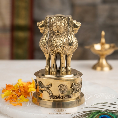 Brass Ashoka Stambh idol on a marble base with diya and marigold petals