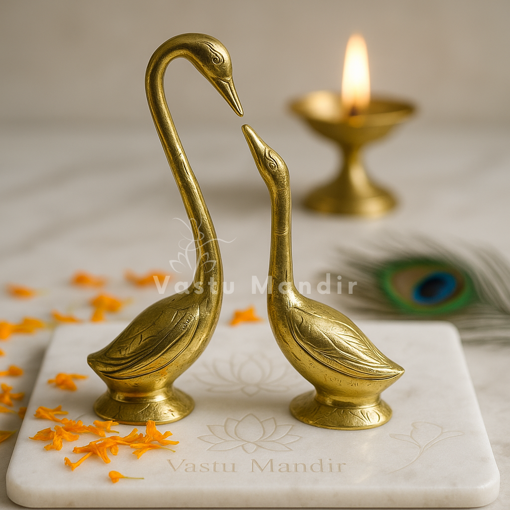 Brass swan pair on a sacred marble plate with peacock feather and diya