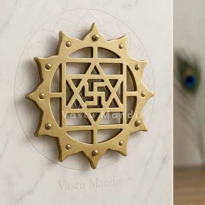Brass Kamal Satiya Vastu wall symbol displayed on a marble plate in a sacred setting