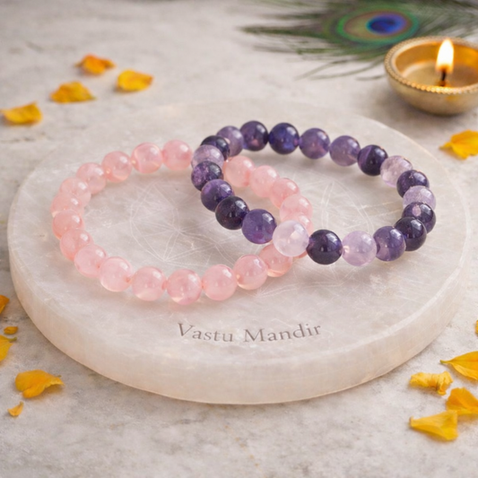 Two beaded bracelets on a marble coaster with decorative elements.