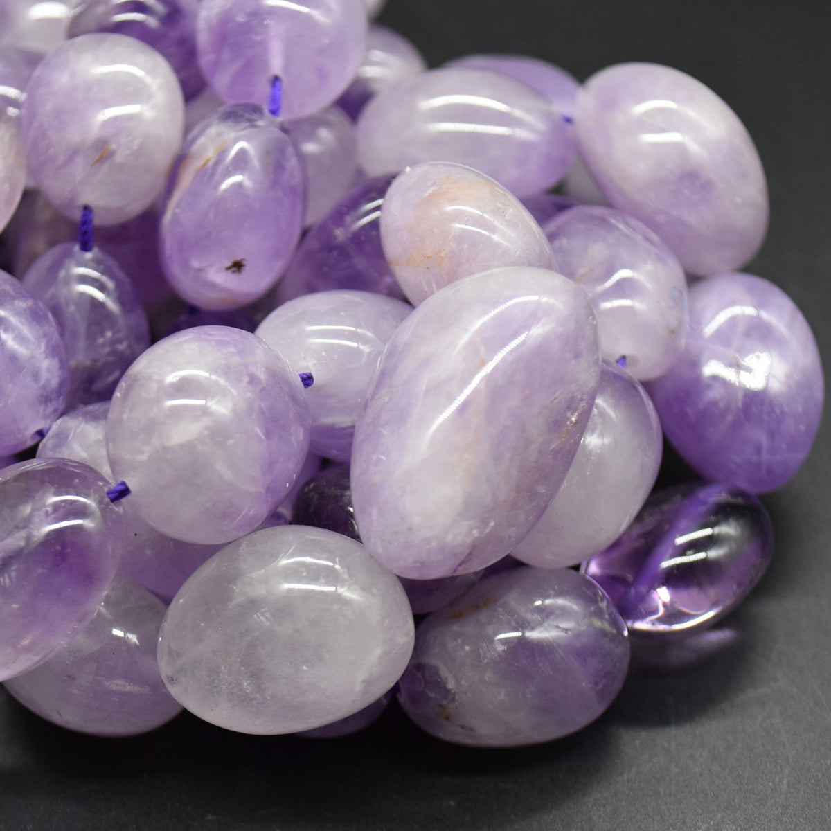 Close-up of pale lavender banded amethyst stones with glossy polished surfaces