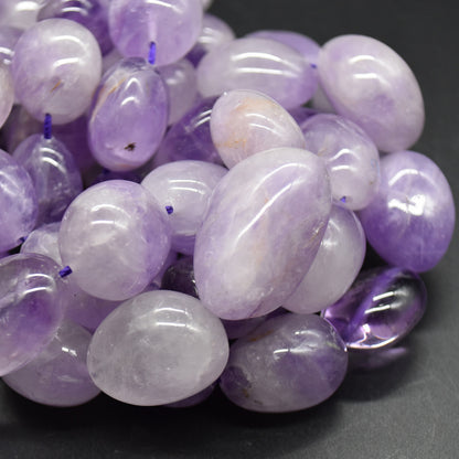 Close-up of pale lavender banded amethyst stones with glossy polished surfaces