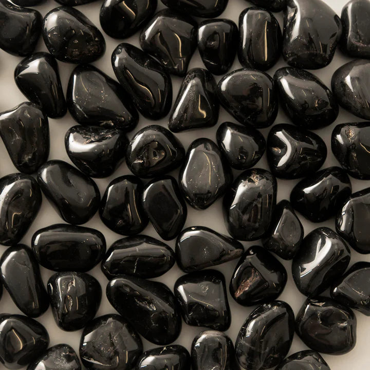 Tight macro view of glossy black onyx stones showing smooth rounded surfaces