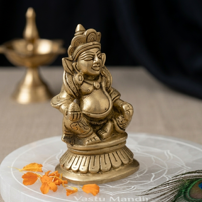 Brass Kuber Ji idol displayed against a black draped studio background