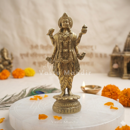 Brass Dhanvantri idol alternate front angle on a white platform with ritual accents