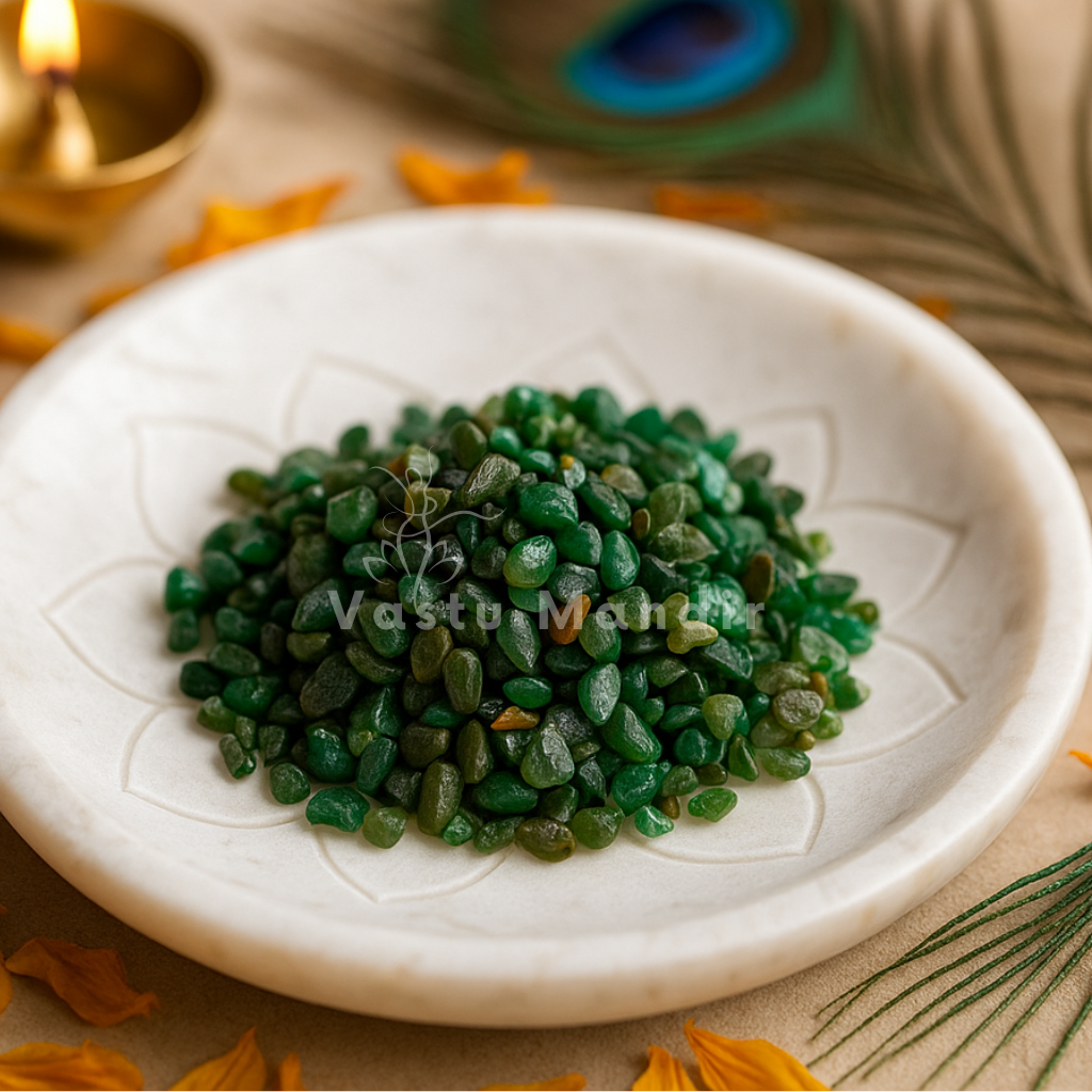 Angled view of emerald crystal chips on a white plate with marigold petals and a peacock feather