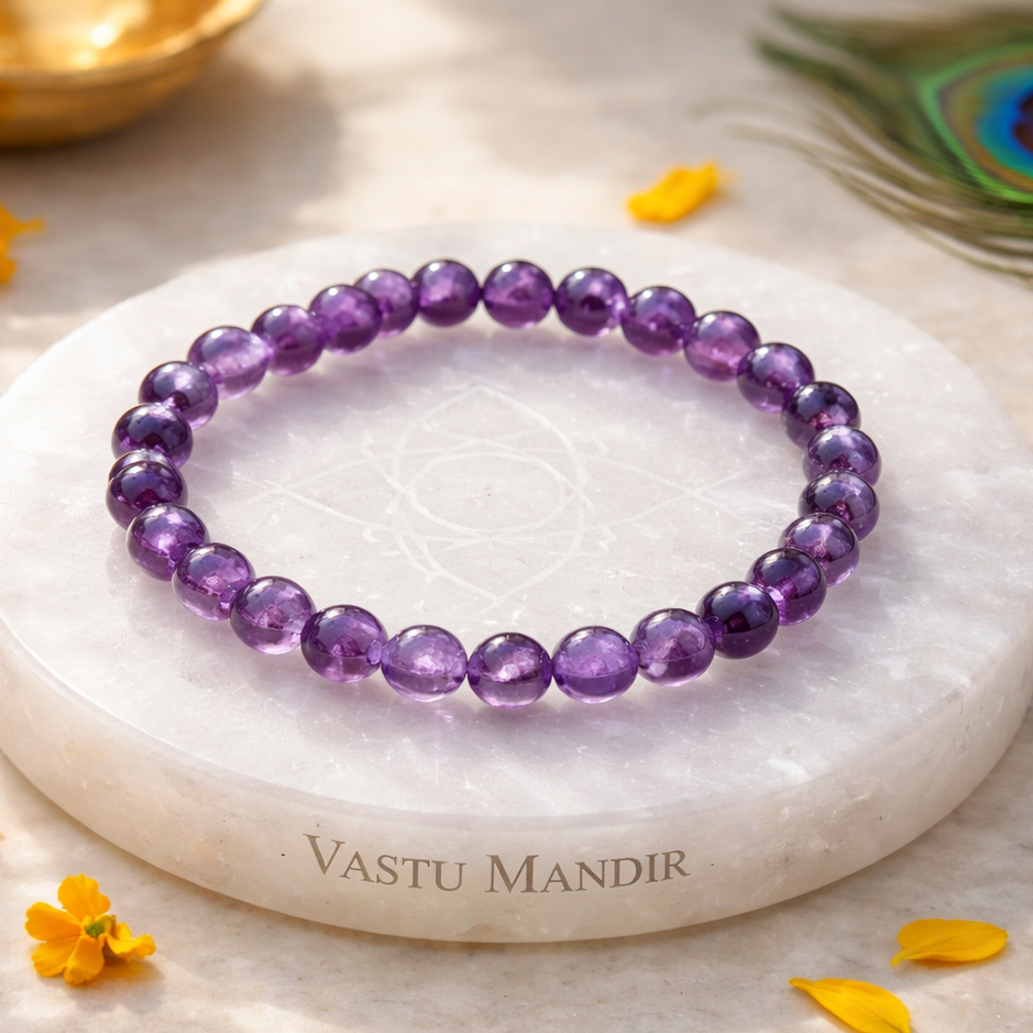 Hydro Amethyst Bracelet on a white marble coaster with 'Vastu Mandir' branding, surrounded by yellow flowers
