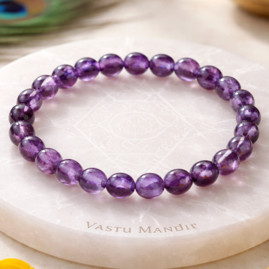 Hydro Amethyst Bracelet on a white marble surface with 'Vastu Mandir' branding, surrounded by yellow flowers