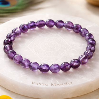Hydro Amethyst Bracelet on a white marble surface with 'Vastu Mandir' branding, surrounded by yellow flowers