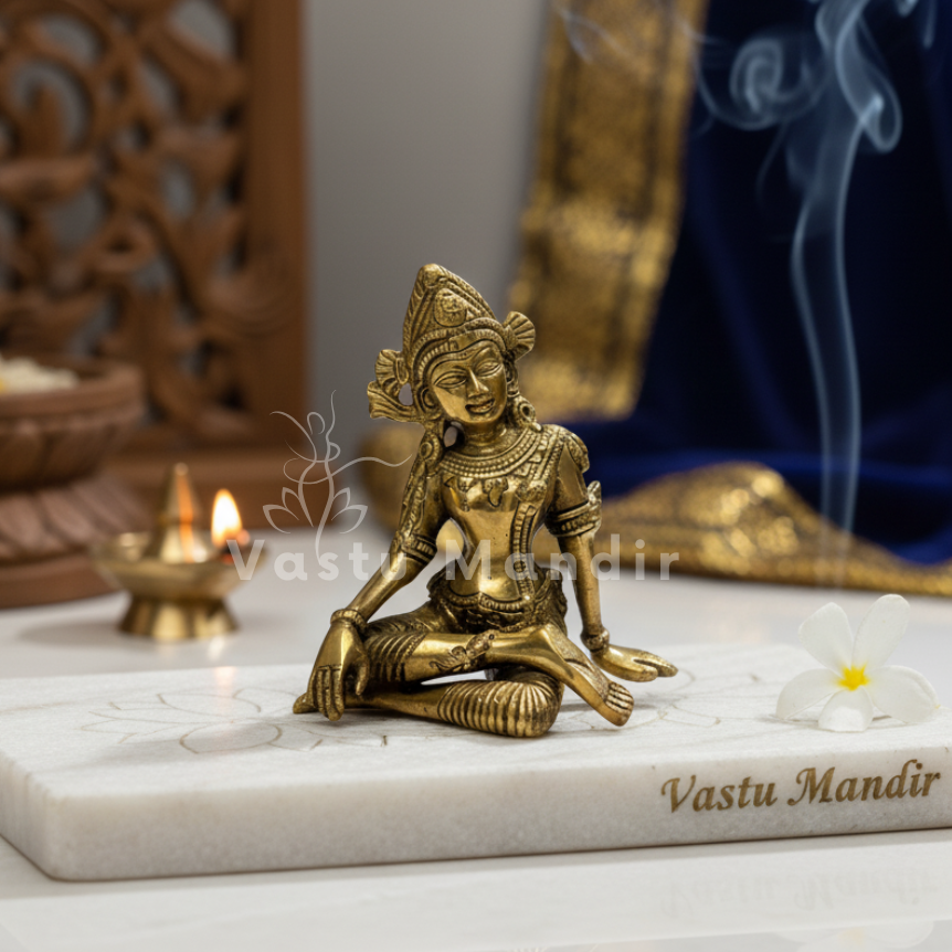 Brass Indra Dev idol displayed in a temple-style setting with blue drapery