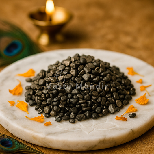 Natural Hematite Chips on a marble plate with decorative elements and a blurred candle in the background