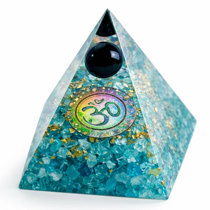 Turquoise pyramid crystal with black sphere and Om symbol on a white background