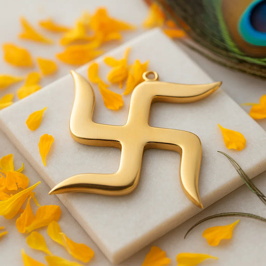 Brass swastika Vastu remedy on a white stone surface with yellow petals and a spool of thread in the background.