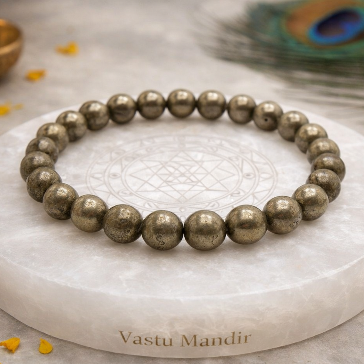 Pyrite bracelet on a marble coaster with 'Vastu Mandir' branding