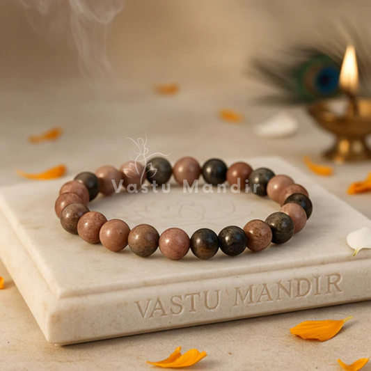 Natural Rhodonite Crystal Bracelet displayed on a round stone plate with marigold petals