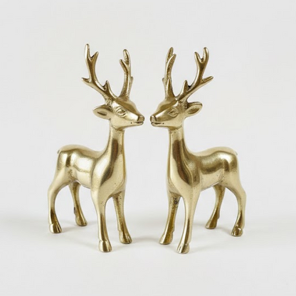 Two brass deer figurines on a white background