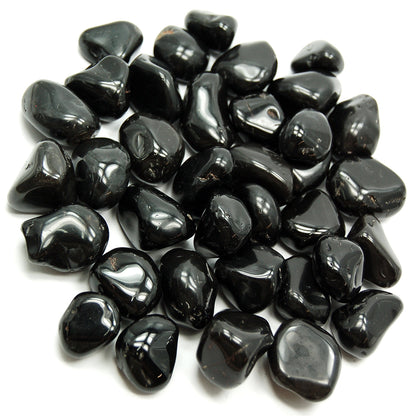 Pile of polished black onyx stones isolated on a clean white background