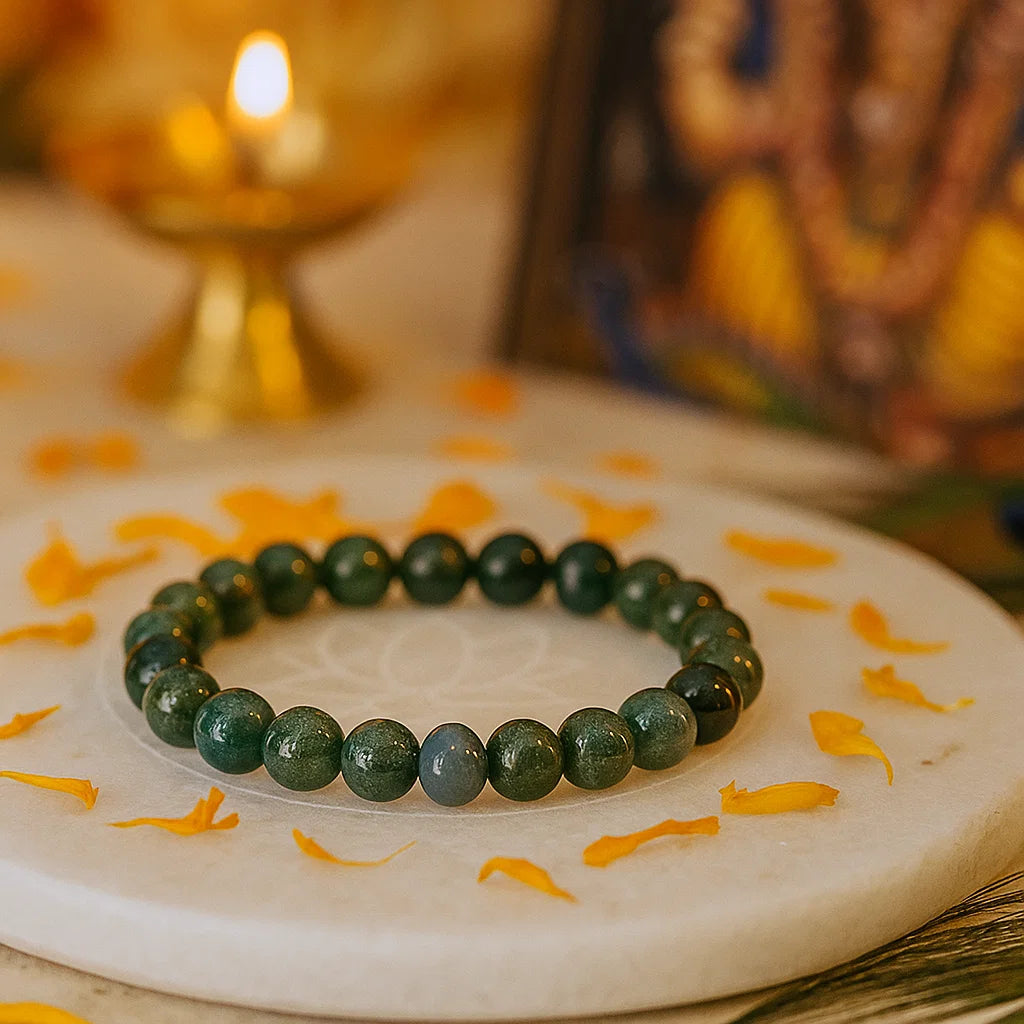 Moss agate crystal bracelet displayed on a marigold-decorated sacred plate