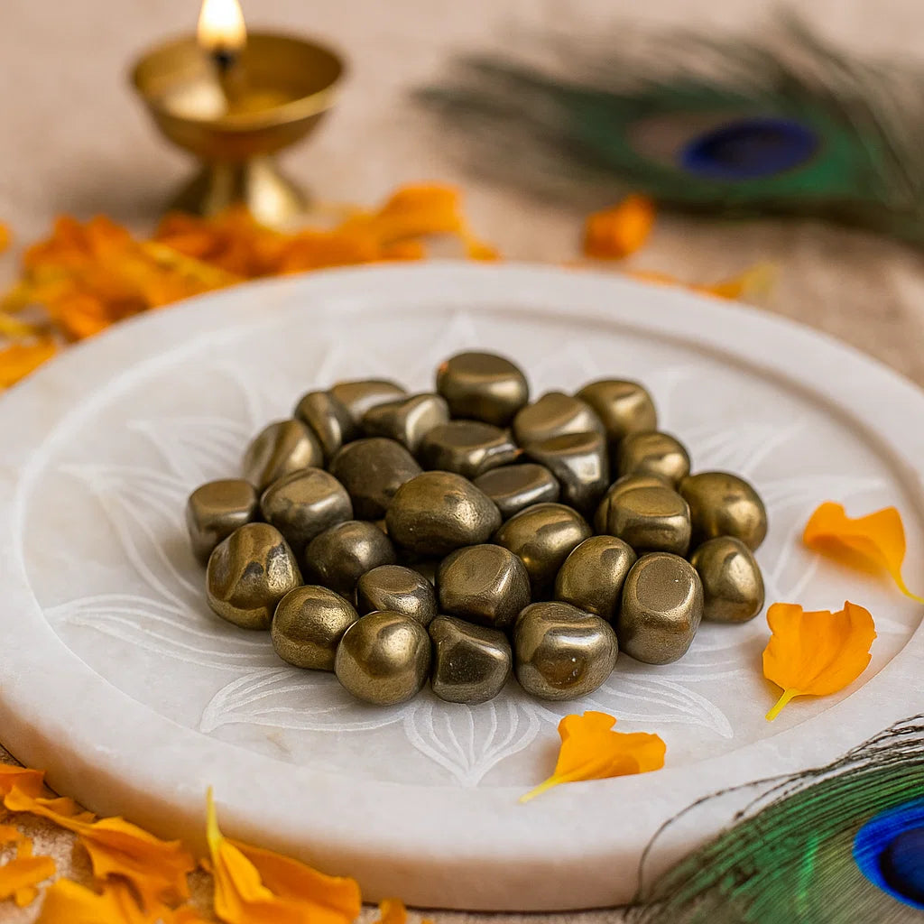 Close view of golden pyrite tumbled stones on a decorative white plate in a softly lit traditional setting