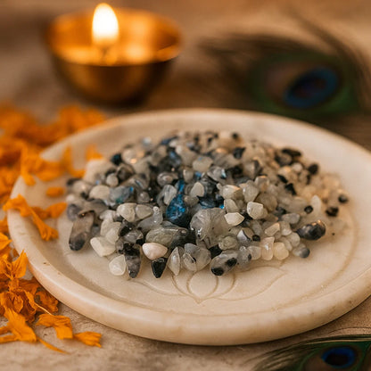 Rainbow moonstone crystal chips displayed in a dark, softly lit spiritual setting