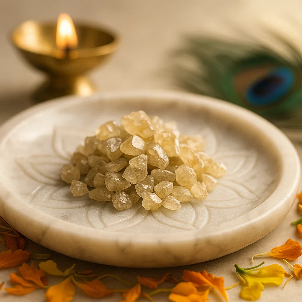 Small pale cat's eye gemstone chips arranged on a white plate with flower petals