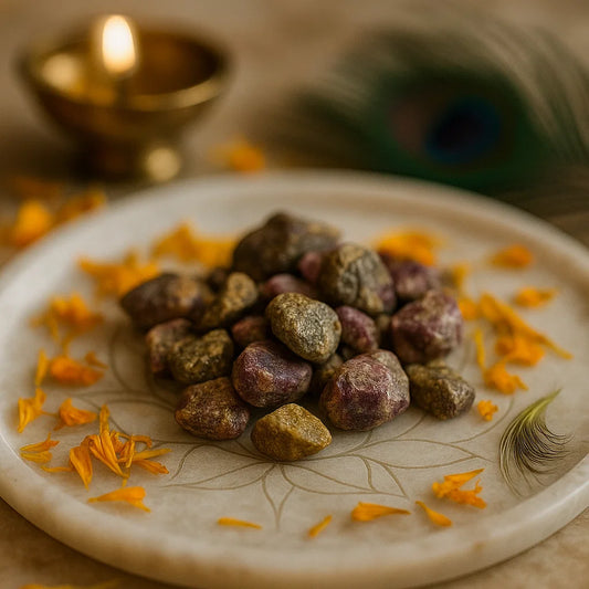 Rough ruby zoisite stones displayed on a white plate with marigold petals and brass decor
