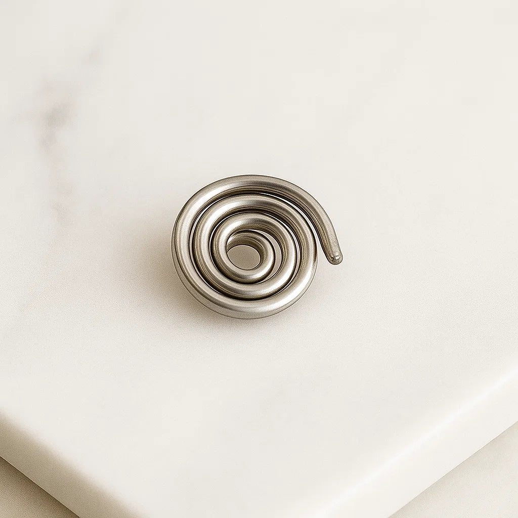 Iron spiral Vastu spring shown from a second angle on a white surface