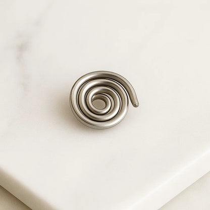 Iron spiral Vastu spring shown from a second angle on a white surface