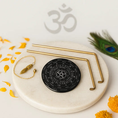 Brass L-rod pair with black dowsing board and pendulum on a sacred marble plate