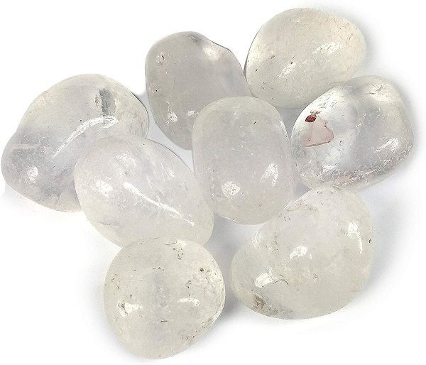 Rounded clear quartz stones grouped closely on a clean white background