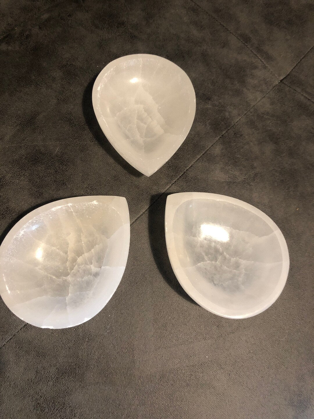 Diya selenite charging bowl presented in a second hand-held view