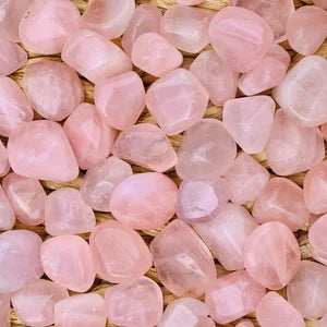 Macro view of rose quartz tumbled stones showing polished surfaces, colour variation and natural markings