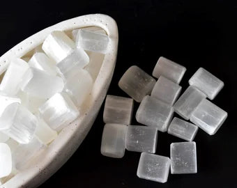 Selenite cubes and short rectangular pieces arranged on a black and white background