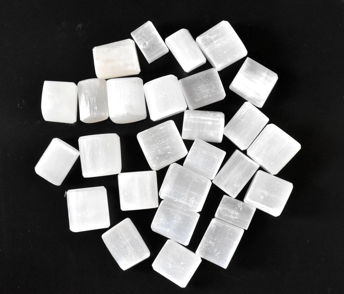 Pile of uniformly cut white selenite cubes on a clean white background
