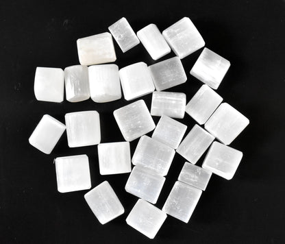 Pile of uniformly cut white selenite cubes on a clean white background