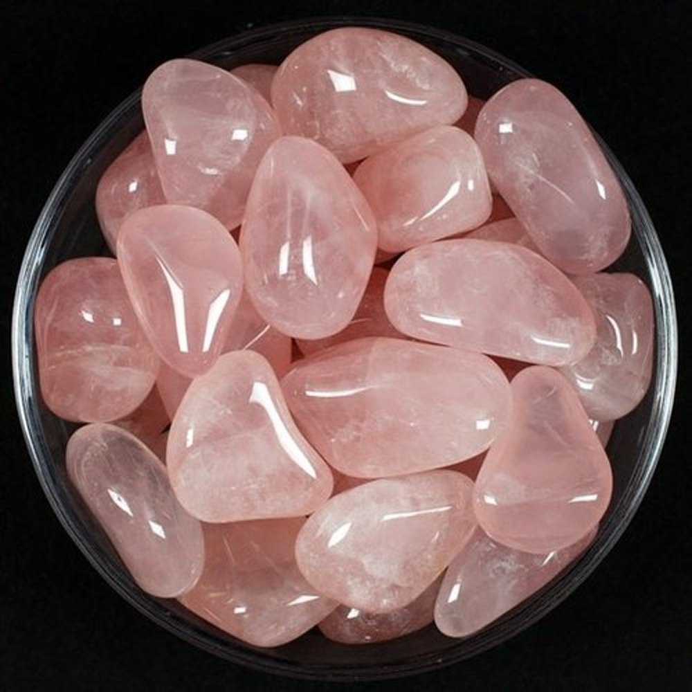 Rose quartz tumbled stones arranged against a dark background for a close product view