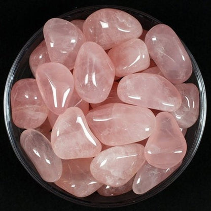 Rose quartz tumbled stones arranged against a dark background for a close product view
