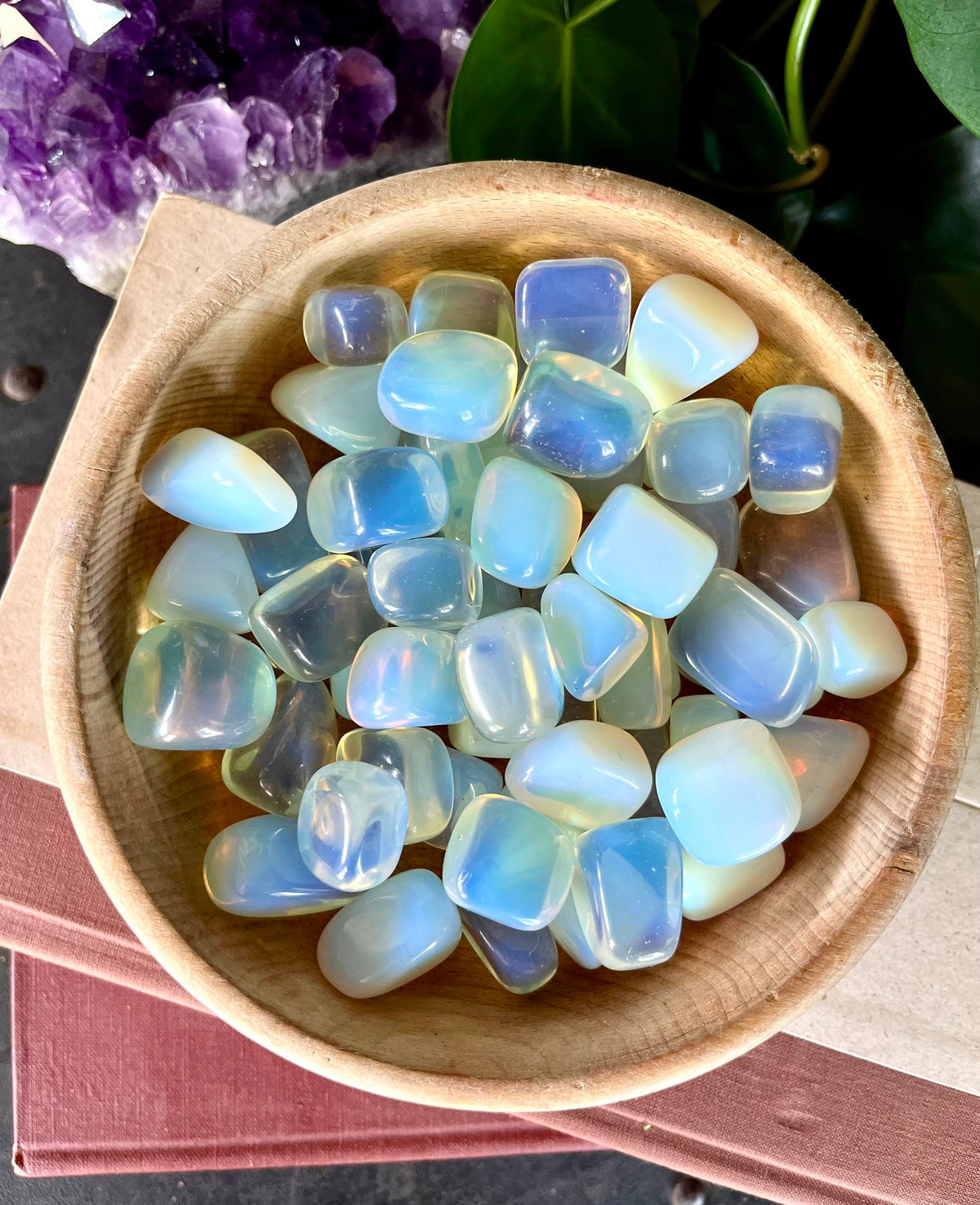 Opalite tumbled stones displayed in a small bowl with a neutral background
