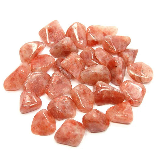 Pile of angular peach-coloured sunstone pieces isolated on a clean white background
