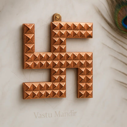 Copper swastik pyramid displayed in a styled sacred setting