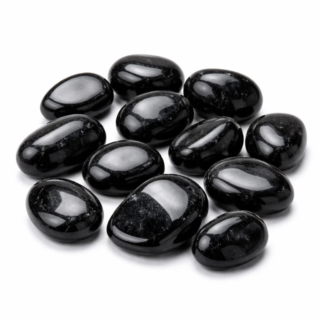 Polished black tourmaline tumbled stones grouped on a clean white background