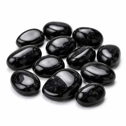 Polished black tourmaline tumbled stones grouped on a clean white background
