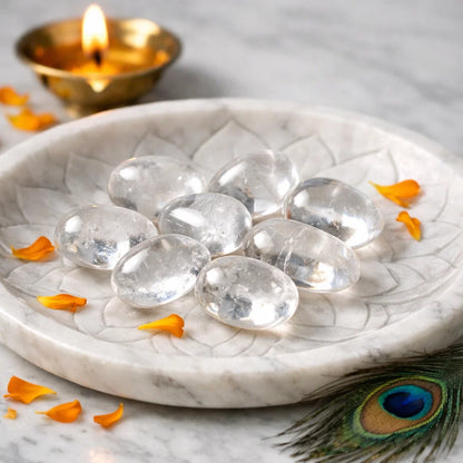 Close view of clear quartz tumbled stones on a decorative white plate in a softly lit traditional setting