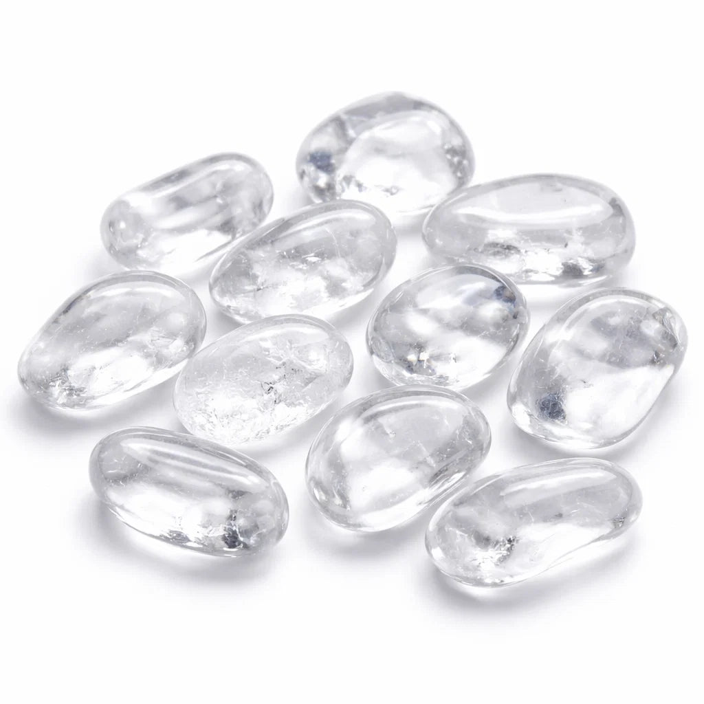 Large clear quartz tumbled stones grouped on a clean white background