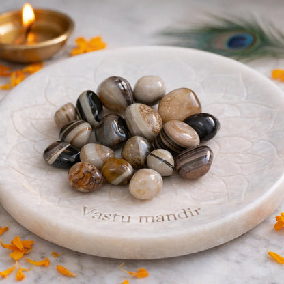 Natural sulemani hakik tumbled stones arranged on a decorative display surface