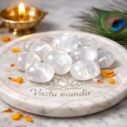 Close view of selenite healing stones on a decorative white plate in a softly lit traditional setting