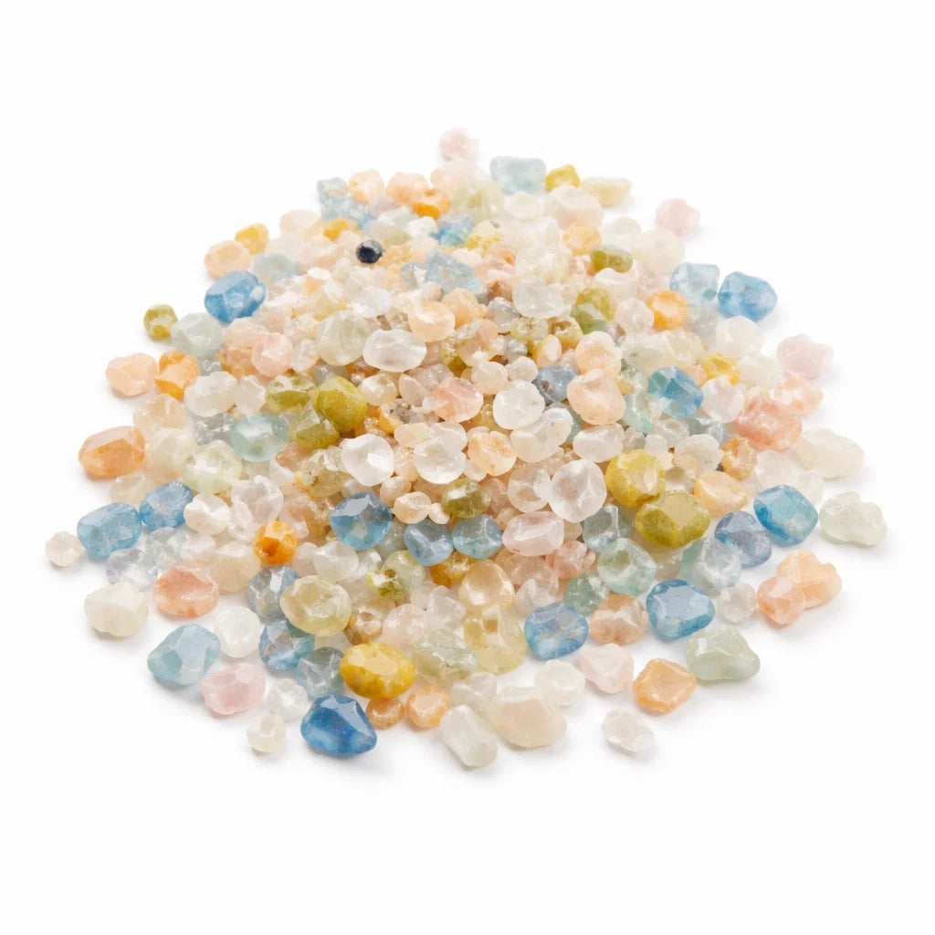 Pile of multicoloured beryl crystal chips on a clean white background